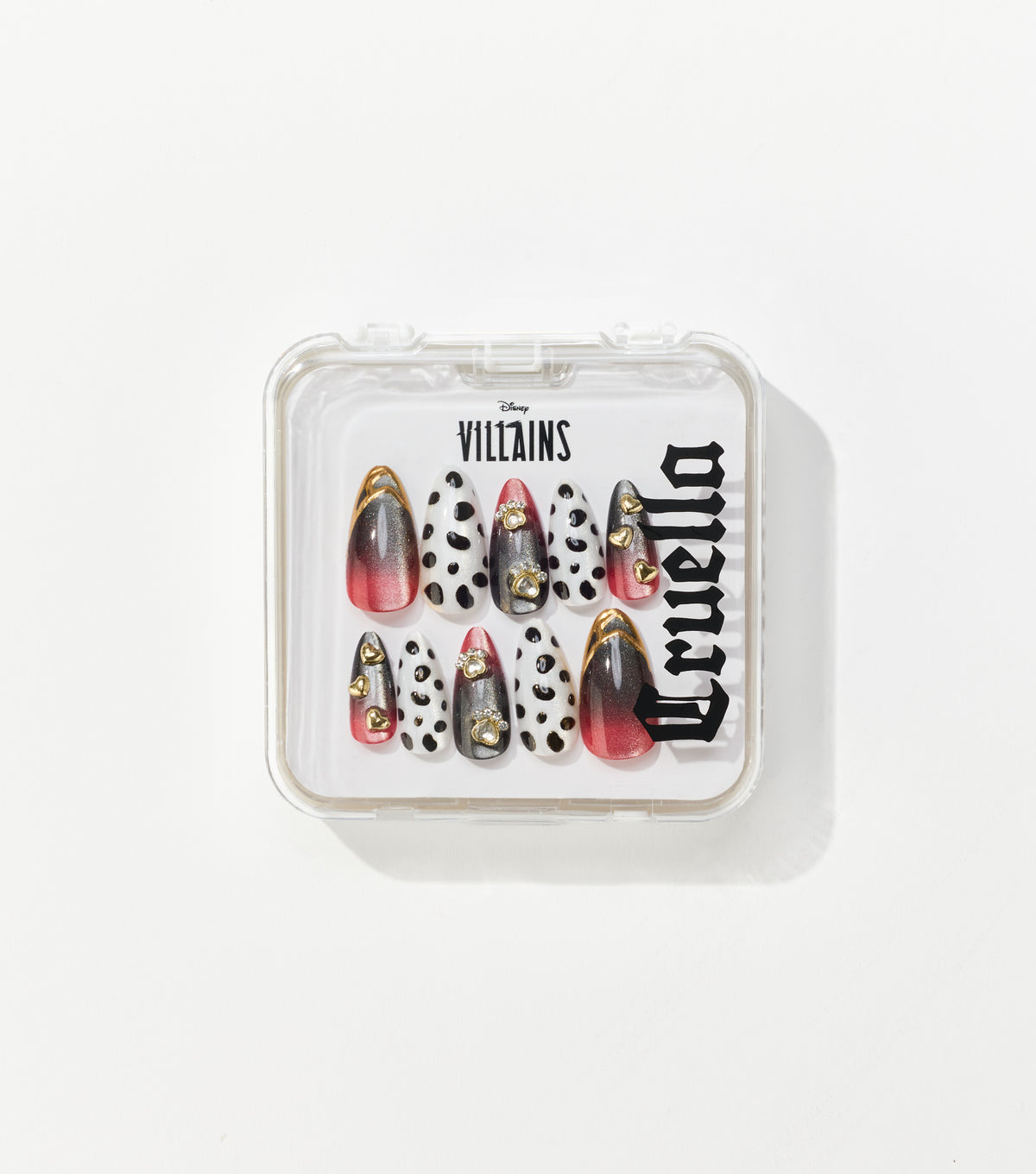 A clear square case holds ten almond-shaped press-on nails in black and white spots, red-black gradients, and gold heart charms.