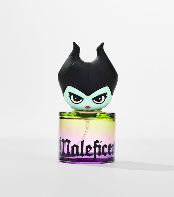 A cylindrical perfume bottle with a green-to-purple gradient and black gothic lettering, topped by a cartoon horned figure with pale green skin.