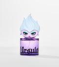 A round purple glass perfume bottle with black gothic lettering, topped by a cartoon figure with pale blue flame-like hair.