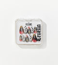 A clear square case holds ten almond-shaped press-on nails in black and white spots, red-black gradients, and gold heart charms.