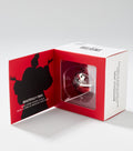 A red and white gift box opens to show a round, glossy red lip balm and a black silhouette of a fur-coated figure.