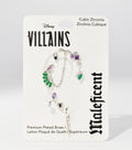 A white Disney Villains Maleficent backing card holds silver earrings and an ear cuff set with green, purple, and black stones.