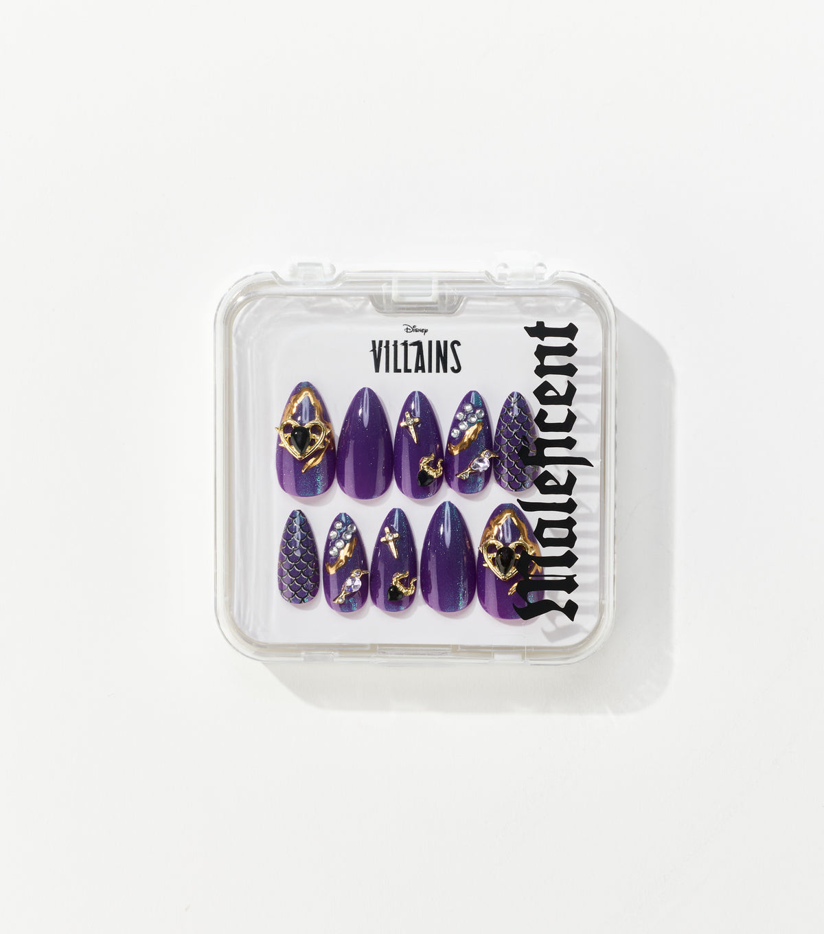 A clear case holds ten purple almond-shaped press-on nails decorated with gold hearts, crosses, rhinestones and scale patterns, labeled Disney Villains Maleficent.