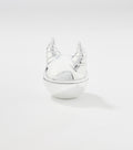 A round silver lip balm container with a glossy finish and a lid shaped like two curved, ridged horns.
