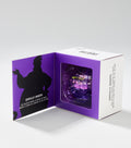 An open purple and white gift box shows a shell-shaped lip balm container behind a clear window, beside a black character silhouette.