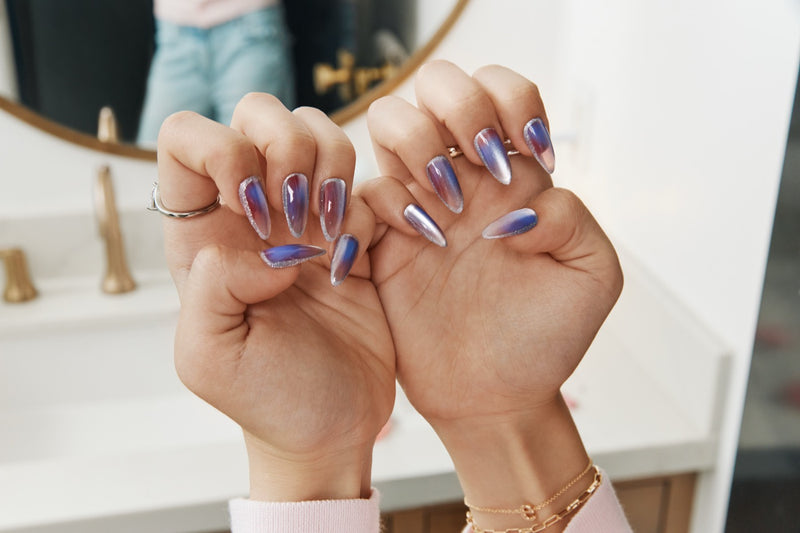 Two hands with chrome ombré nails held up side by side