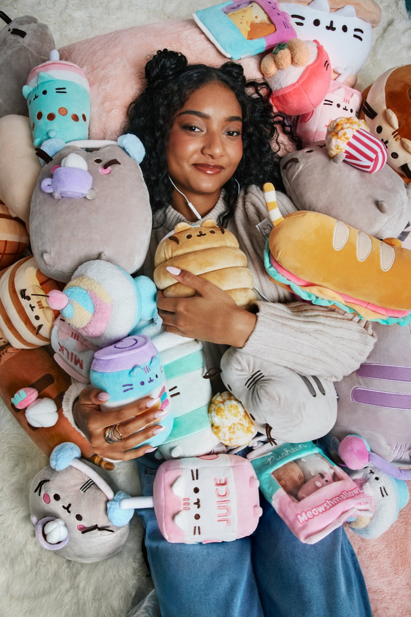 A person surrounded by a pile of plush character toys